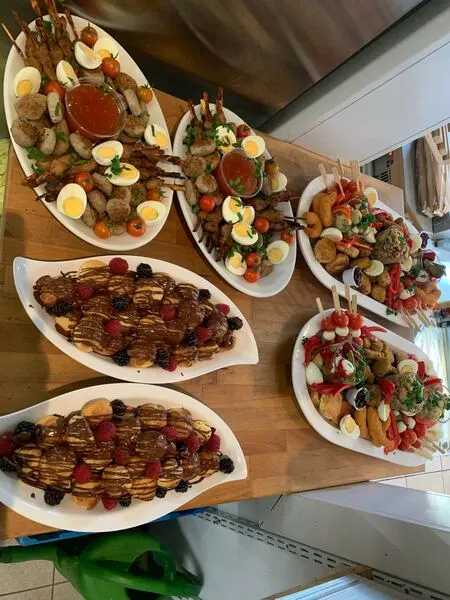 Fingerfood-Platten mit Spießchen, Eierhälften, Mini-Frikadellen und süßen Häppchen